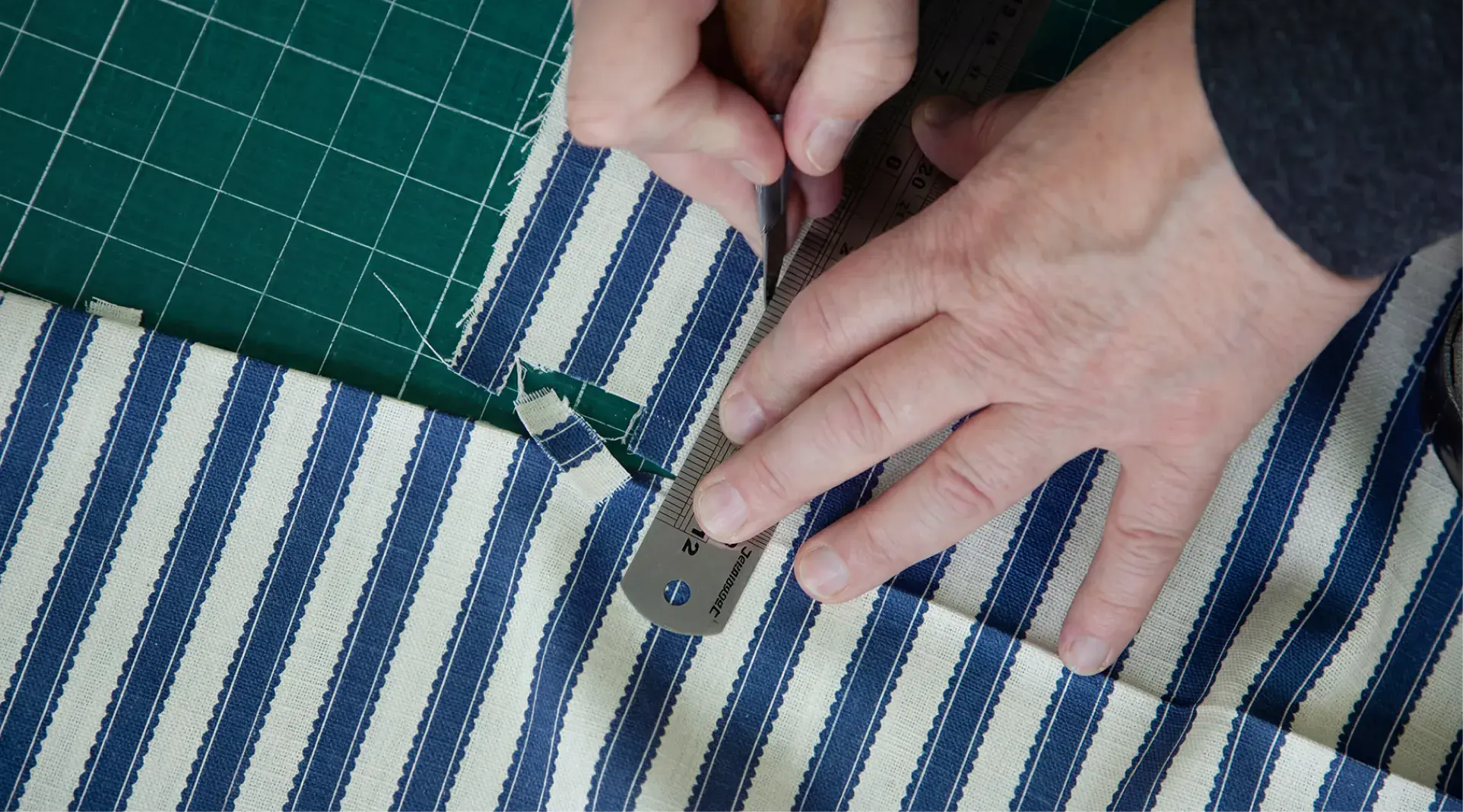 Craftsperson cutting Sanderson fabric